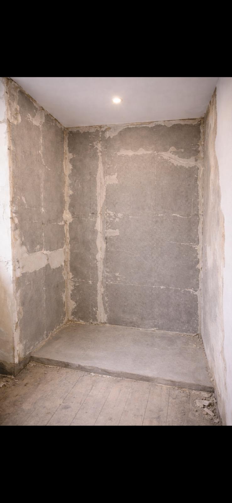 Shower area stripped back to cement backer board and bare walls before renovation